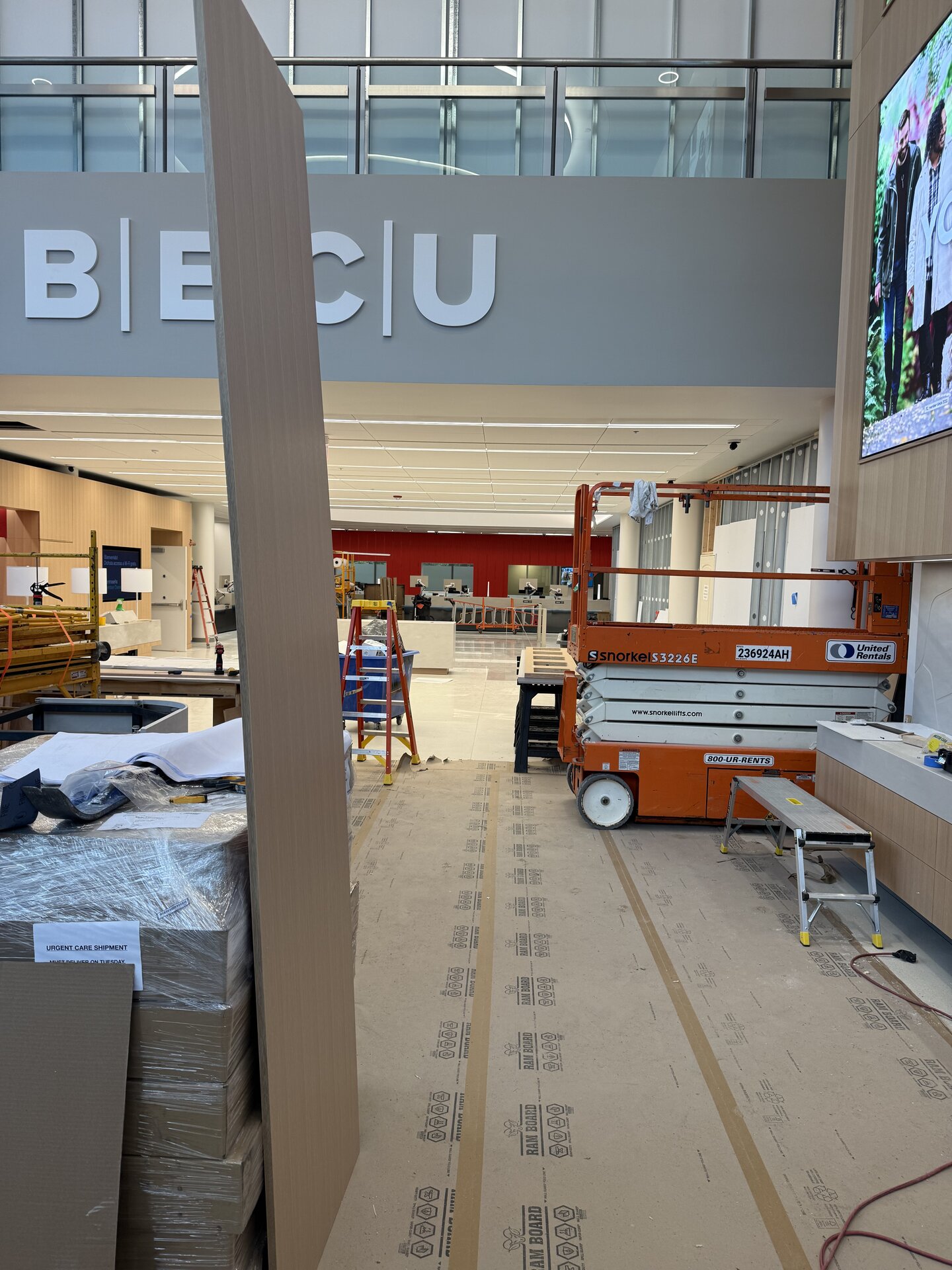 BECU Everett Financial Center lobby under construction with BECU signage, millwork, and a scissor lift
